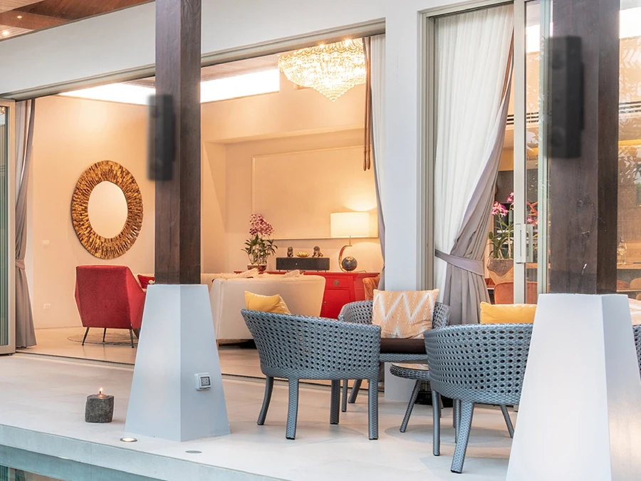 A lit terrace and pool at dusk with Lithe Audio iO1 outdoor speakers